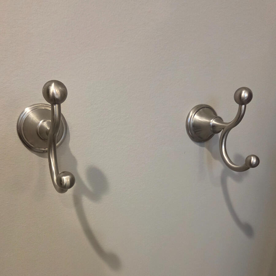 Secured towel hooks with proper anchoring and a clean finish.
